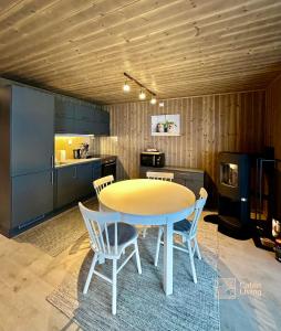 a kitchen with a table and chairs in a room at Super apartment right on the slopes and stadium in Sjusjøen