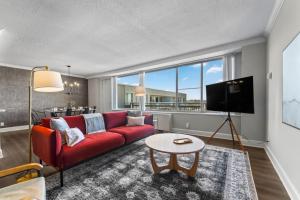 uma sala de estar com um sofá vermelho e uma mesa em Penthouse Living near DC and Metro em Arlington