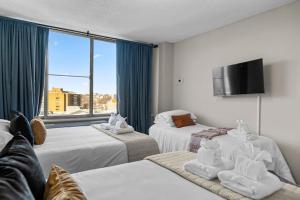 um quarto de hotel com três camas e uma televisão de ecrã plano em Penthouse Living near DC and Metro em Arlington