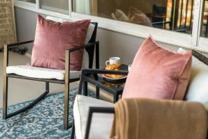 a room with two chairs and a table with pillows at Chic DC Getaway Near Metro in Arlington