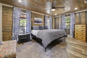 a bedroom with a bed in a room with wooden walls at Deluxe Forest Haven Hot Tub Sleeps 10 in Stephens Gap +30 photos