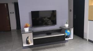 a flat screen tv sitting on top of a entertainment center at UnnisHome in Adūr