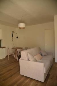 uma sala de estar com um sofá branco e uma mesa em Sky and Vineyards - Nespolo - em La Morra