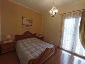 Schlafzimmer mit einem Bett und einem Fenster mit einem Kronleuchter in der Unterkunft Kantouni Bedroom in Faraklata