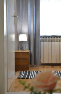 Apartment Ematours في بوزيغا: غرفة معيشة مع خزانة ملابس ومصباح