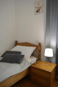 a bedroom with a bed and a nightstand with a lamp at Apartment Ematours in Požega