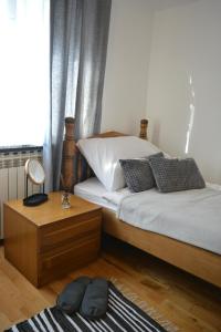 a bedroom with two beds and a mirror and a table at Apartment Ematours in Požega
