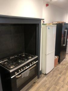 a kitchen with a black stove and a refrigerator at Fast book Homes. Close to Uni in Hull