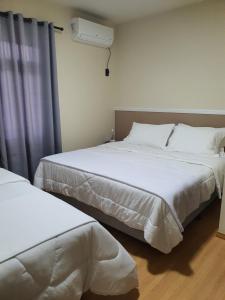 two beds sitting next to each other in a room at Dein Platz Pousada in Timbó