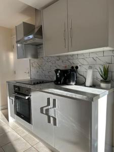 a kitchen with white cabinets and a counter top at Modern 1 Bed Flat In Derby City in Derby