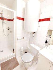 a white bathroom with a toilet and a shower at Coeur de station ESF - Pied de pistes Baïkonour in Le Corbier
