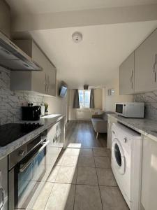 a large kitchen with a washer and dryer in it at Modern 1 Bed Flat In Derby City in Derby