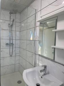 y baño blanco con lavabo y ducha. en Modern 1 Bed Flat In Derby City, en Derby