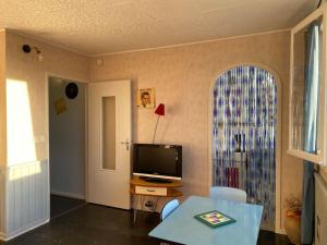 a living room with a television and a table at Ambiance vintage pour 2 in Saint-Cyr-sur-Loire