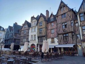 a group of old buildings with tables and umbrellas at Ambiance vintage pour 2 in Saint-Cyr-sur-Loire