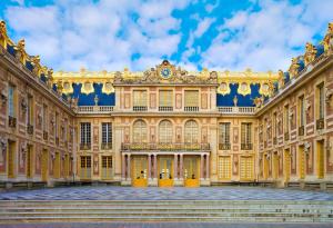a large building with a clock on the side of it at Studette Rémilly à Versailles in Versailles