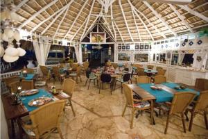 a dining room with tables and chairs in a restaurant at Hotel Casa Coson in Las Terrenas
