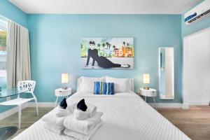 ein blaues Schlafzimmer mit einem Bett mit einer Katze drauf in der Unterkunft The New Yorker Miami Hotel in Miami