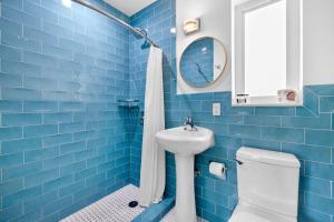 a blue tiled bathroom with a toilet and a sink at The New Yorker Miami Hotel in Miami