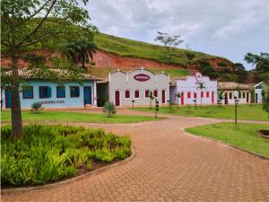 a large white building with a hill in the background at Fazenda Borges in Rio Piracicaba