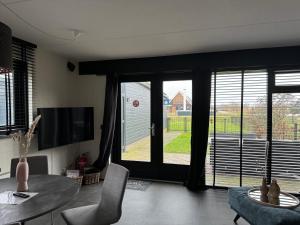 a living room with a table and chairs and sliding glass doors at Hubanet in Giethoorn