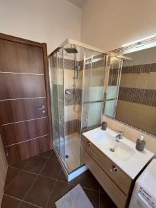 La salle de bains est pourvue d'une douche et d'un lavabo. dans l'établissement L'ORCHIDHEA APARTMENT, à Savillan