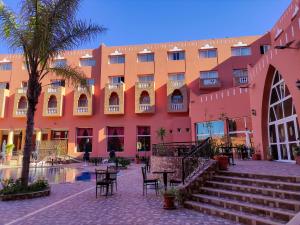 Hotel Idou Tiznit في تزنيت: مبنى به طاولات وكراسي أمامه