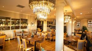 a restaurant with tables and chairs and a chandelier at Beamish Park Hotel in Beamish