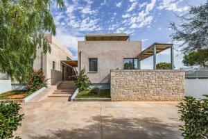 una casa con una pared de piedra en Callisto Seaside Homes & Suites en Marathopolis