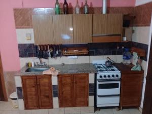 una pequeña cocina con fogones y fregadero en POSADA CUATRO HERMANOS en Tinogasta