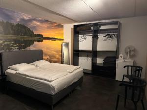 1 dormitorio con 1 cama y una pintura de un lago en Hubanet, en Giethoorn