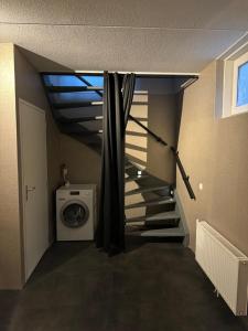 a laundry room with a staircase and a washing machine at Hubanet in Giethoorn
