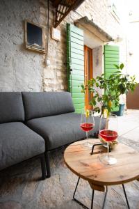 eine Couch und zwei Gläser Wein auf dem Tisch in der Unterkunft Residenza Borgo Valpolicella in SantʼAmbrogio di Valpolicella