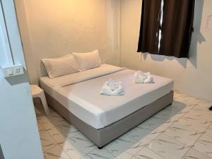 a bed with two white towels on top of it at Phangan Dream box in Baan Tai