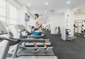 a man walking on a treadmill in a gym at Horizon Grey Apartment & Spa in Skopje