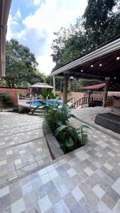 a patio with a picnic table and a pavilion at Cabaña con piscina en Minca in Minca