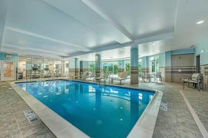 a large swimming pool in a hotel lobby at Holiday Inn Express & Suites Charleston Arpt-Conv Ctr Area by IHG in Charleston