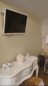 une télévision sur un mur au-dessus d'une table blanche dans l'établissement Grand studio 29, à Faro