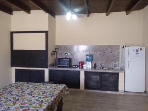 a room with a kitchen with a bed and a refrigerator at Paz y Eva in Salta