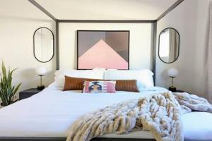 a bedroom with a white bed with a blanket and mirrors at Designer 1BR 1BA Culver City Sony Studios in Los Angeles