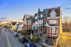 a house on a street with cars parked in front of it at Charming Studio-Panoramic View-Your Pittsburgh Sanctuary in Pittsburgh