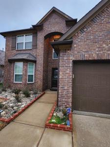 ein Backsteinhaus mit einer Garage und einer Auffahrt in der Unterkunft Shella Home in Missouri City