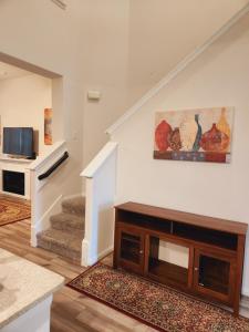 a living room with a couch and a tv at Shella Home in Missouri City