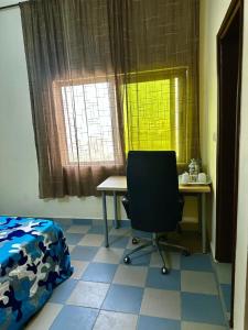 a room with a desk and a chair and a window at Private Room In Cotonou Home in Cotonou