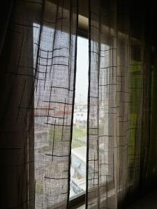 a window with curtains in a room at Private Room In Cotonou Home in Cotonou