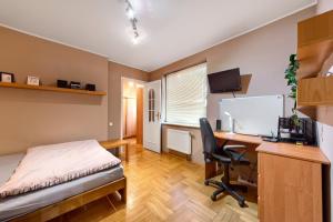 sypialnia z biurkiem, łóżkiem i komputerem w obiekcie Apartament Kapelanka CoWork w Krakowie
