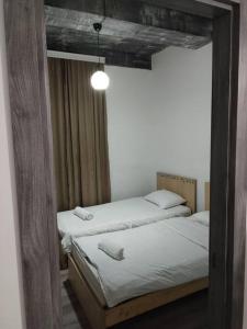 2 Einzelbetten in einem Zimmer mit Spiegel in der Unterkunft Comfortable apartment Kutaisi. in Kutaissi