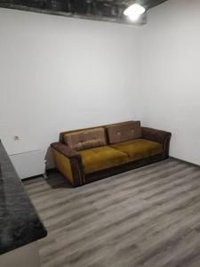 eine braune Couch in der Ecke eines Zimmers in der Unterkunft Comfortable apartment Kutaisi. in Kutaissi