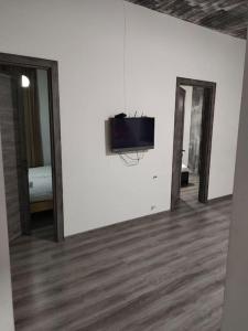 Zimmer mit einem TV an einer weißen Wand in der Unterkunft Comfortable apartment Kutaisi. in Kutaissi