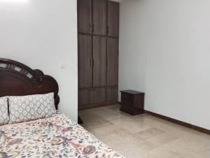 a bedroom with a bed and a wooden cabinet at Bourbon Bliss guest house in Rawalpindi